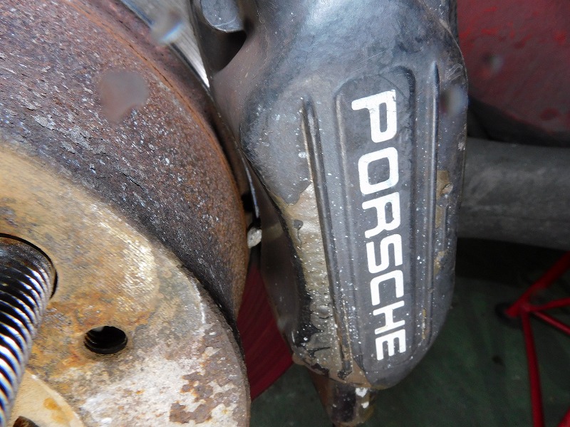 ポルシェ964ブレーキキャリパーとドラムの間に小石が挟まっている